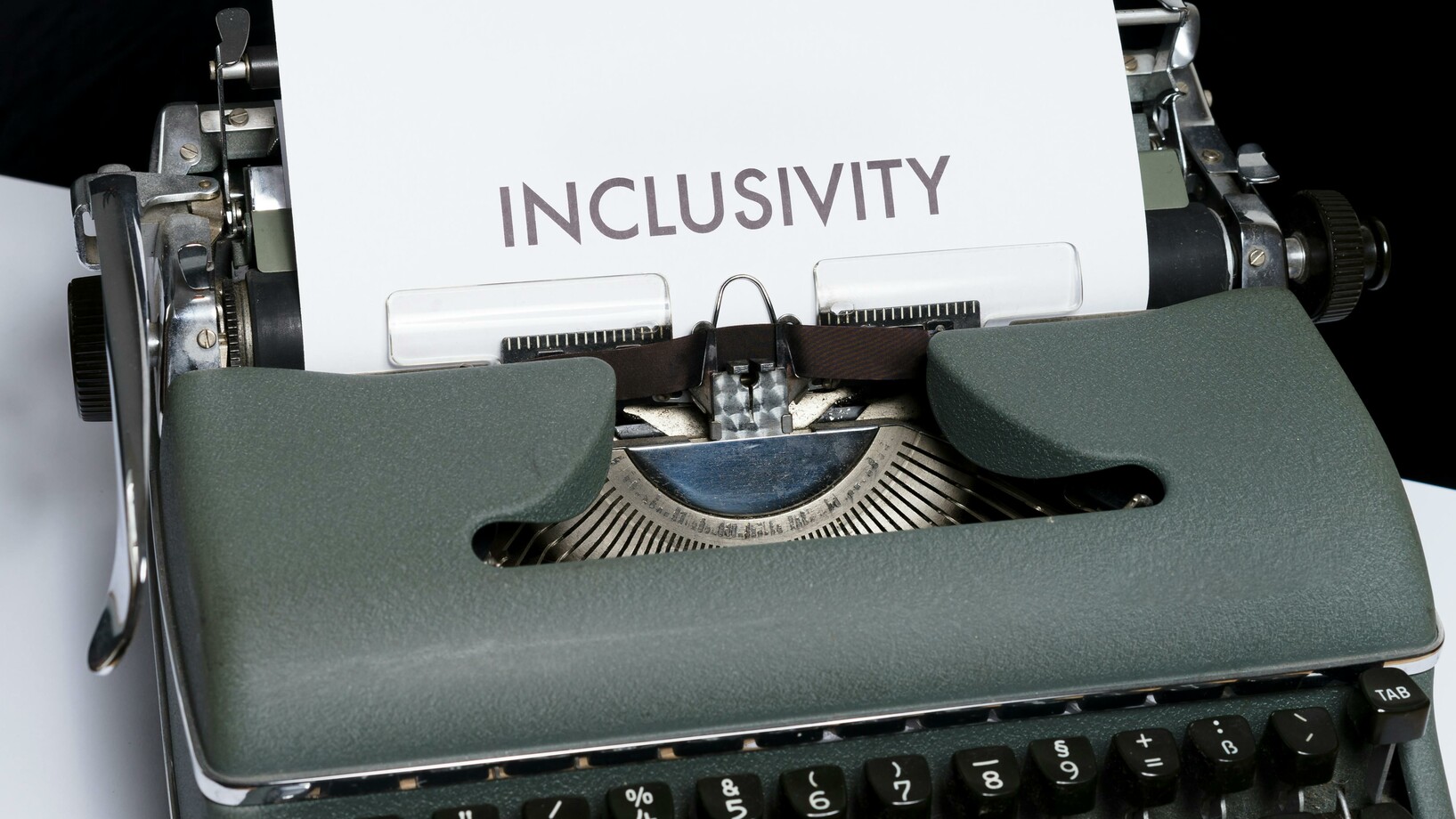 Weisses Papier mit Text "Inclusivity" auf Schreibmaschine